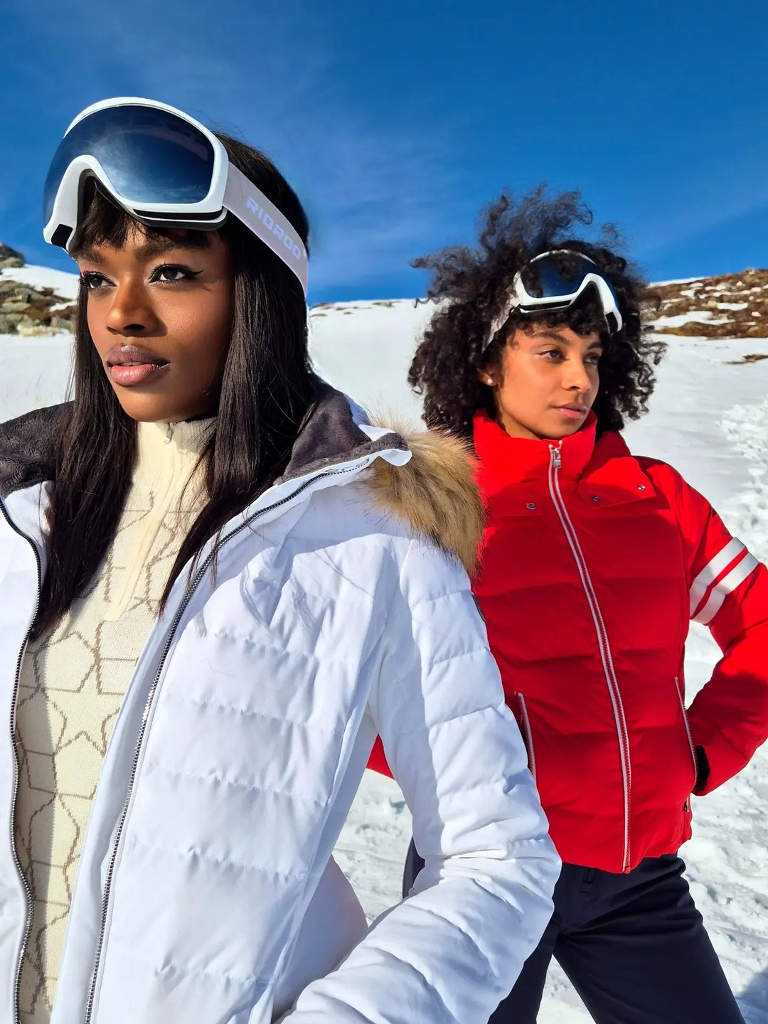 Women wearing FERA Julia Parka with faux fur and Kate Parka ski jackets, showcasing insulated outerwear designed for warmth, weather protection, and mountain performance.